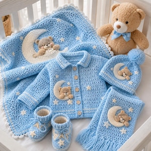 Pode incluir: Um conjunto de croch&ecirc; azul beb&ecirc; com um cobertor, jaqueta, chap&eacute;u, cachecol e botinhas. Cada item tem um urso de pel&uacute;cia e um aplique de lua. Um urso de pel&uacute;cia com uma gravata azul tamb&eacute;m est&aacute; presente. O conjunto &eacute; exibido em um ber&ccedil;o branco.