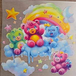 Könnte beinhalten: Ein bunter Aufkleberbogen mit vier Cartoon-Bären in Grün-, Rosa- und Blautönen, die auf flauschigen blauen Wolken sitzen. Das Design umfasst einen leuchtenden Regenbogen, gelbe Sterne und kleine rosa Sterne auf einem transparenten Hintergrund.