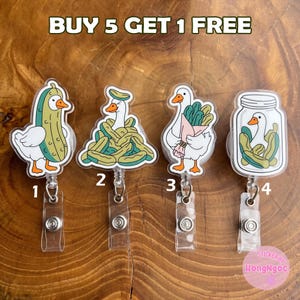 May include: Four badge reels featuring white goose illustrations with pickle themes, labelled 1 to 4. The designs include a goose in a pickle suit, a goose in a pile of pickles, a goose holding a pickle bouquet, and a goose inside a pickle jar.