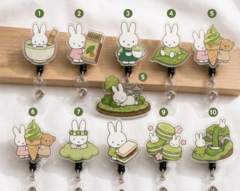 Op de afbeelding: Een collectie van tien acryl badgehouders met het konijn Miffy in diverse groen getinte scènes, waaronder matcha thee, ijsjes, macarons en natuurlandschappen. Elke badgehouder is voorzien van een doorzichtig plastic riempje en drukknoop.