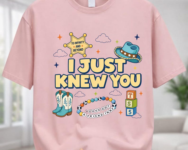 May include: A light pink t-shirt featuring a graphic print with the text I JUST KNEW YOU, a yellow sheriff star with TO INFINITY AND BEYOND, a blue cowboy hat, turquoise cowboy boots, a beaded bracelet with YOU'VE GOT A FRIEND IN ME, and blocks.