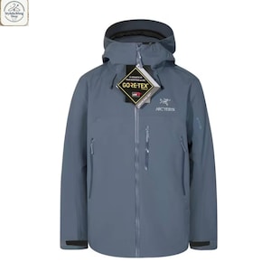 May include: A slate blue Arc'teryx Gore-Tex jacket with a hood, zipper closure, and multiple pockets. The jacket has the Gore-Tex and Arc'teryx logos on the front. The jacket is designed for outdoor activities.