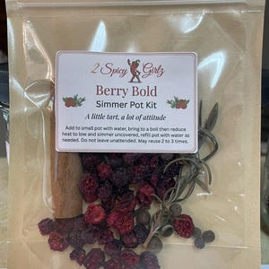 May include: A clear plastic bag contains a "Berry Bold" simmer pot kit. The kit includes dried berries, cinnamon sticks, and herbs. The label reads "2 Spicy Girlz" and "A little tart, a lot of attitude."