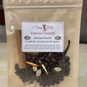 May include: A clear plastic bag containing an "Espresso Yourself" simmer pot kit. The kit includes coffee beans, cinnamon sticks, cardamom pods, and other spices. The label reads "2 Spicy Girlz" and includes instructions.