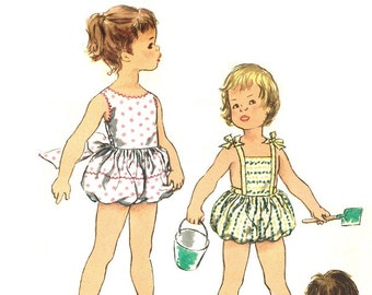 May include: Illustration of children's swimwear. One child wears a white swimsuit with pink polka dots and a large bow. Another child wears a yellow and green striped swimsuit. A third child is also wearing a striped swimsuit.