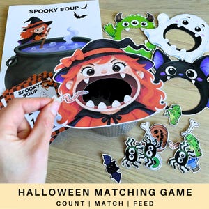 May include: A Halloween matching game set featuring a large cutout of a witch with an open mouth, a Spooky Soup instruction sheet, and various small paper cutouts including spiders, frogs, bats, and bones for feeding the witch character.