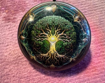 May include: A round pendant with a silver bail. The pendant features a detailed image of a tree with a glowing center, set against a green and teal background. The tree's branches and roots are golden.