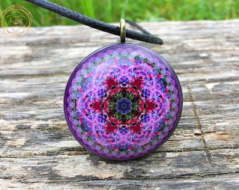 May include: A round pendant necklace with a purple, pink, and green mandala design. The pendant is made of glass and has a silver-toned metal bail.