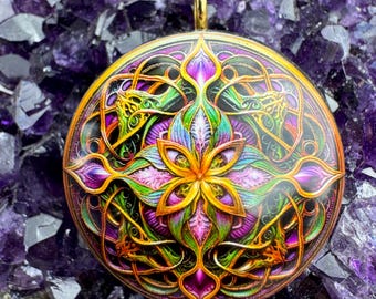 May include: A round, gold-toned pendant with a colorful, intricate design. The design features a central flower with swirling, leafy patterns in shades of green, purple, pink, and yellow.