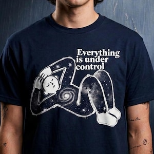 May include: A navy blue short-sleeved t-shirt featuring a white graphic of a person lying down with a galaxy-filled body and a spiral nebula at the center. The text Everything is under control is printed in white above the graphic.
