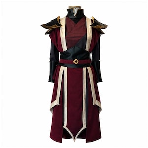 May include: A long-sleeved costume featuring a deep burgundy and black tunic with a high collar, structured shoulder pauldrons, and a waist belt with a gold-toned buckle. The garment includes cream-colored trim along the front panels and skirt.