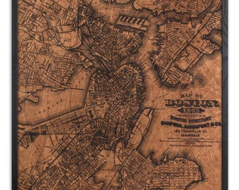 May include: A vintage wood-burned map of Boston, Massachusetts from 1883. The map shows the city's streets and waterways, and includes the text "MAP OF BOSTON 1883 PUBLISHED BY THE BOSTON DIRECTORY 155 FRANKLIN ST. BOSTON".