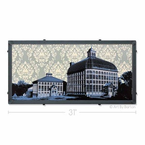 May include: A blue and white print of two glass buildings with a damask pattern background. The print is framed in a black frame and measures 31 inches wide. "Art By Barton" is printed in the bottom right corner.