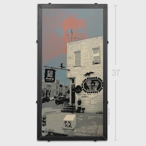 May include: A framed print of a street scene with a tavern sign that reads "Arnold Lee Tavern". The artwork is in shades of gray, black, and white, with a touch of pink and blue in the sky. The print is 31 inches tall.