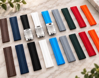 May include: A collection of rubber watch straps in various colors including brown, navy, black, white, blue, gray, dark green, red, and orange. Several straps feature silver-toned metal deployment clasps with the engraved text BREITLING.