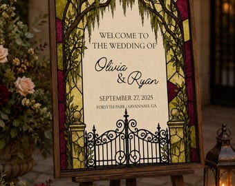 May include: A rectangular wedding sign in a dark wood frame featuring a stained glass design with deep red and yellow panels. The centre displays the text: WELCOME TO THE WEDDING OF Olivia & Ryan SEPTEMBER 27, 2025 FORSYTH PARK | SAVANNAH, GA.