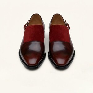 Handcrafted mens dress loafers in dark cherry leather resting on a clean cream background.