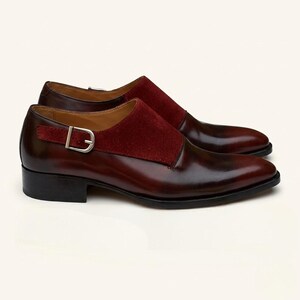 Close up of polished wine red leather and soft crimson suede on custom monk strap footwear.