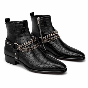 Puede incluir: Un par de botines negros con un patrón de relieve de cocodrilo. Cada bota incluye un detalle de arnés de cadena de metal plateado envuelto alrededor del tobillo, asegurado con remaches metálicos y una cremallera lateral con tirador plateado.