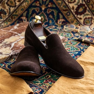 Men’s handcrafted brown velvet loafers featuring elegant matching leather tassels.