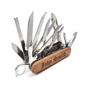 May include: A multi-tool with various stainless steel implements, including a knife, saw, and pliers. The wooden handle is engraved with the name "John Smith". The tools are open, showcasing the versatility of the device.