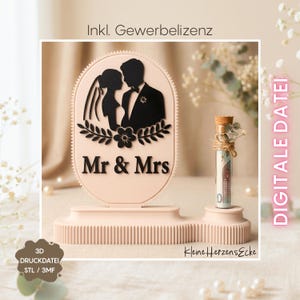 Pode incluir: Decoração de casamento rosa claro com silhueta de noivos e texto "Mr & Mrs". Um pequeno tubo de vidro com rolha e raminhos decorativos sobre um pedestal. O texto "DIGITALE DATEI" é visível.