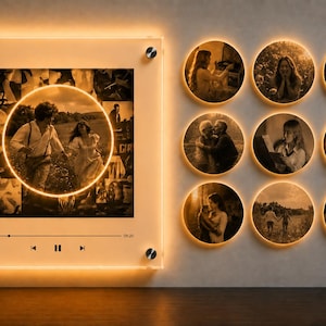 May include: A square acrylic wall display with warm LED backlighting featuring a central circular photo collage and playback controls, accompanied by nine smaller circular wall-mounted photo frames, each illuminated with a warm golden glow.