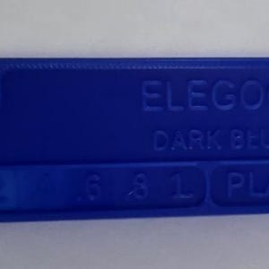 K&ouml;nnte beinhalten: Ein dunkelblaues ELEGOO PLA-Filament-Farbmuster. Das rechteckige Muster hat abgerundete Ecken und ein Loch an einem Ende. Der Text "ELEGOO DARK BLUE" und Zahlen sind auf der Oberfl&auml;che gepr&auml;gt.