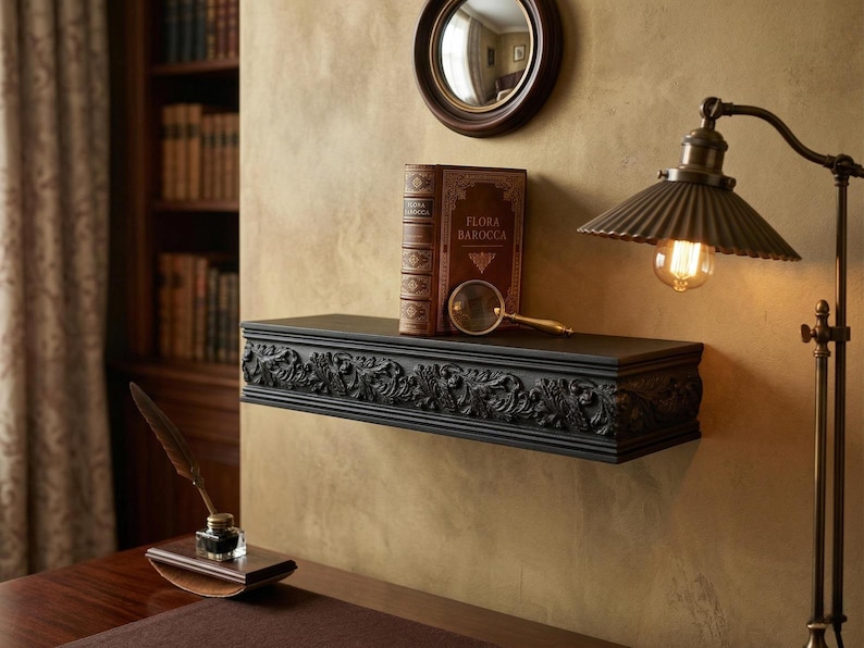 May include: A black, ornate shelf with a carved floral design holds a vintage book, a magnifying glass, and a brown leather-bound book. A vintage-style lamp with a pleated shade and a round mirror are also visible.