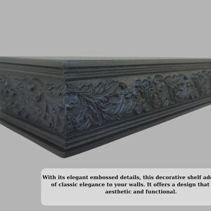 May include: A dark grey decorative shelf with embossed floral and foliate detailing. The shelf is rectangular and designed for wall mounting. The design adds a touch of classic elegance. The shelf is approximately 76 cm long.