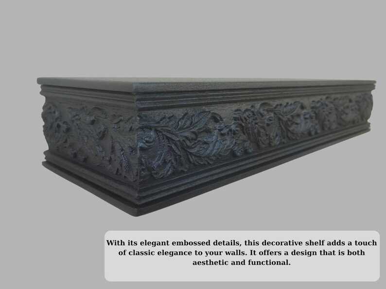 May include: A dark grey decorative shelf with embossed floral and foliate detailing. The shelf is rectangular and designed for wall mounting. The design adds a touch of classic elegance. The shelf is approximately 76 cm long.