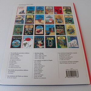 May include: A white back cover of a Tintin book featuring a grid of twenty-four colorful comic book cover illustrations. Below the grid, there are three columns of black text listing various titles and a barcode with the ISBN 2-203-00118-9.