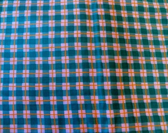 May include: A teal and orange plaid fabric with a white background. The fabric has a woven texture.