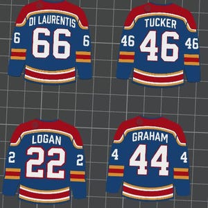 May include: Four blue hockey jerseys with red shoulders and white numbers. Each jersey has a different name and number: Di Laurentis 66, Tucker 46, Logan 22, and Graham 44. The jerseys have gold and white stripes.