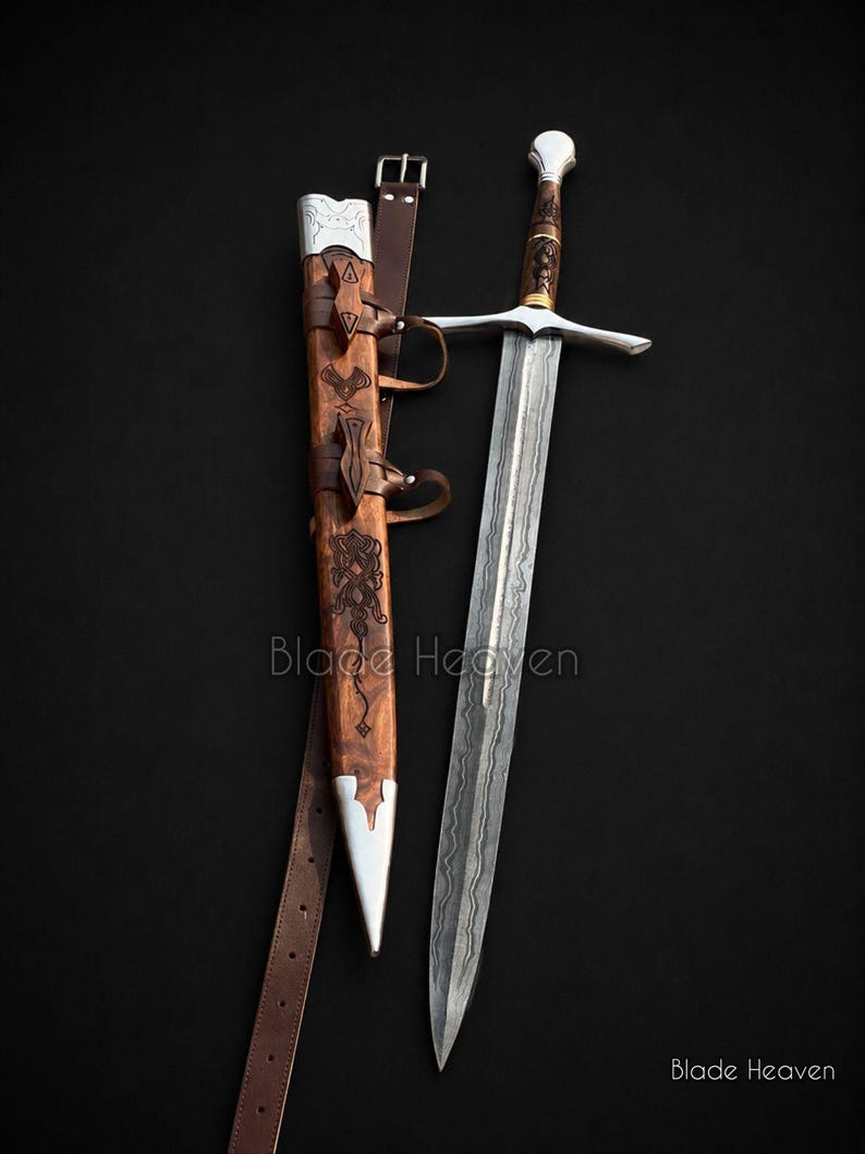 May include: A steel sword with a patterned blade and a detailed hilt, accompanied by a wooden scabbard featuring metal accents and a brown leather belt. The scabbard displays intricate carvings and the text Blade Heaven is visible on the image.