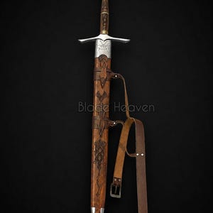 May include: A longsword with a silver pommel, crossguard, and metal throat, featuring a wooden grip and scabbard with intricate dark engravings. The scabbard includes a brown leather belt with a metal buckle. The text Blade Heaven is visible.