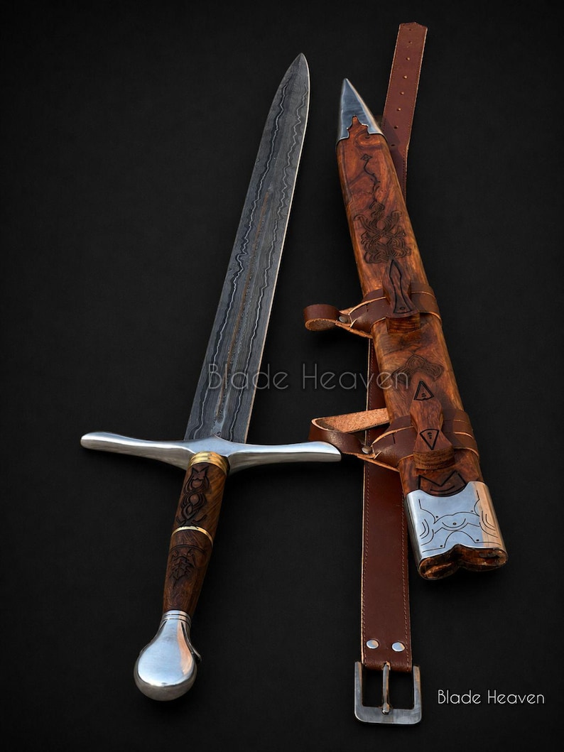 May include: A double-edged sword with a patterned Damascus steel blade, a wooden handle with metal accents, and a matching wooden scabbard featuring metal fittings and a brown leather belt. The text Blade Heaven is visible on the image.