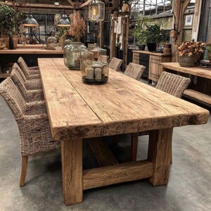 May include: A substantial, rectangular wooden dining table with a distressed, aged look. The table is supported by thick, square legs and surrounded by woven wicker chairs. Decorative glass jars and candles are placed on the table's surface, creating a warm atmosphere.