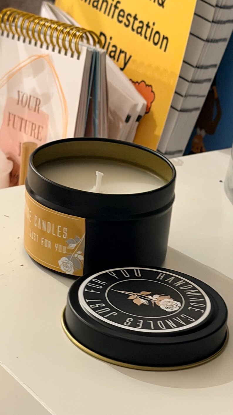 K&ouml;nnte beinhalten: Eine schwarze Kerzendose mit goldenem Rand, gef&uuml;llt mit wei&szlig;em Wachs und einem mittigen Docht. Das Etikett lautet "Rose Candles Just For You" mit einer Rosengrafik. Der Deckel tr&auml;gt den Text "Handmade Candles Just For You" um eine Rose.
