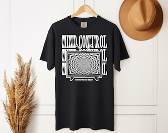 May include: Black t-shirt with a white graphic design. The design features the words "MIND CONTROL" above a television screen with a swirling, hypnotic pattern. The words "MAINSTREAM MEDIA" are below the screen.