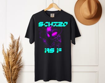 May include: A black short-sleeve t-shirt featuring a graphic of an alien with bright pink eyes and a glowing forehead, holding a cigarette. The text "SCHIZO" appears in cyan above the alien, and "AS F" appears in cyan below the graphic.