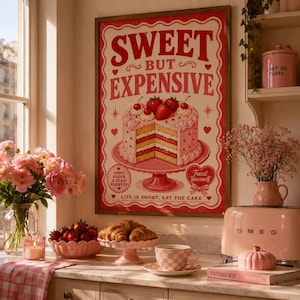 Puede incluir: Un póster enmarcado de estilo vintage con el texto "SWEET BUT EXPENSIVE" y una ilustración de pastel. Una tostadora rosa, una taza de té rosa y un cuenco de fresas están sobre una encimera. También hay un jarrón con flores rosas y una vela.
