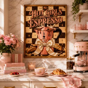 Puede incluir: Una máquina de espresso rosa y una impresión enmarcada con el texto "Hot Girls Drink Espresso" se exhiben en una encimera de mármol. También se ven una taza de café, un cruasán y una máquina de espresso Smeg rosa.