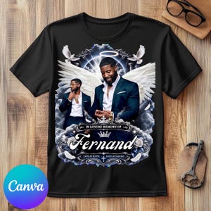 May include: A black t-shirt featuring a memorial graphic with two images of a man in a dark suit, large white angel wings, a glowing halo, white doves, and clouds. The text reads IN LOVING MEMORY OF Fernand, DATE OF BIRTH, and DATE OF PASSING.