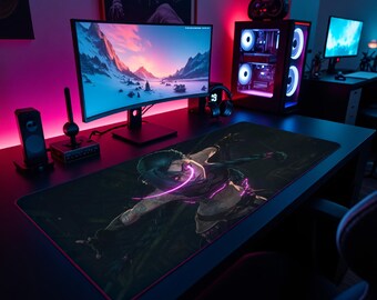Puede incluir: Una alfombrilla de escritorio rectangular negra con una ilustración gráfica de un personaje de pelo oscuro y detalles en rosa brillante. La alfombrilla tiene un borde rojo fino y está colocada sobre una mesa oscura frente a un monitor.