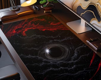 May include: A rectangular desk mat featuring a space-themed design with a central black hole surrounded by swirling white stardust and vibrant red nebula clouds against a deep black background, covering the surface of a dark wooden desk.