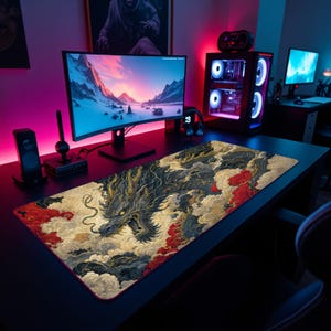 May include: A rectangular desk mat featuring a detailed illustration of a dragon surrounded by swirling clouds in shades of black, gold, and red. The mat is positioned on a dark desk surface in front of a computer monitor and gaming tower.