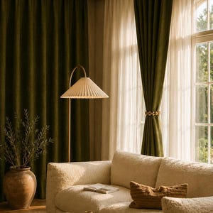 Peut inclure: Int&eacute;rieur de salon avec rideaux en velours vert olive et rideaux blancs transparents. Un canap&eacute; cr&egrave;me avec un coussin textur&eacute; est sous un lampadaire dor&eacute; avec un abat-jour pliss&eacute;. Un grand vase en c&eacute;ramique avec de la verdure.