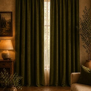 Peut inclure: Rideaux en velours vert olive, tombant jusqu'au sol, encadrant une fen&ecirc;tre. Les rideaux pr&eacute;sentent un aspect riche et textur&eacute;. La pi&egrave;ce pr&eacute;sente une palette de couleurs neutres, avec des meubles en bois et un tapis tiss&eacute;, cr&eacute;ant une ambiance chaleureuse.