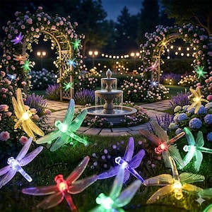 May include: A collection of translucent, multi-colored dragonfly-shaped LED lights scattered across a lawn. Each dragonfly features textured wings and a glowing center in shades of red, green, yellow, blue, and purple, connected by a thin wire.